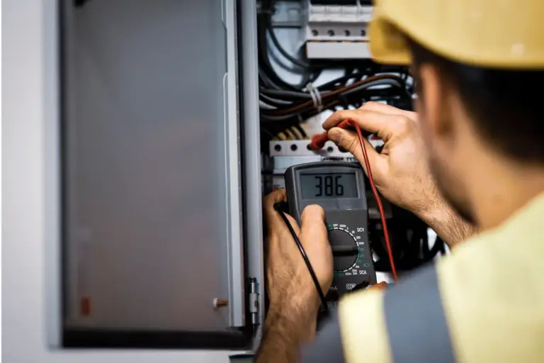 Electricista midiendo voltaje en panel eléctrico con multímetro